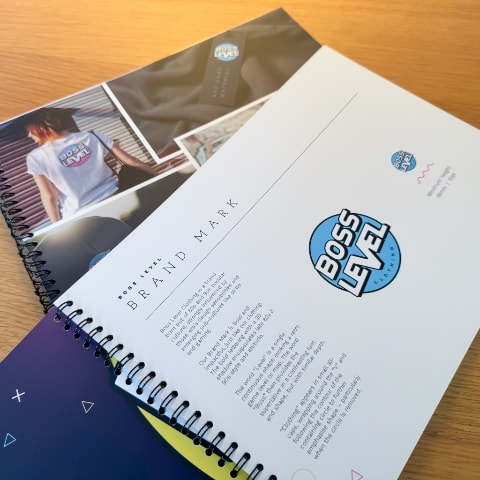 Photo of an open brand book showing off the brand mark for Boss Level Clothing.